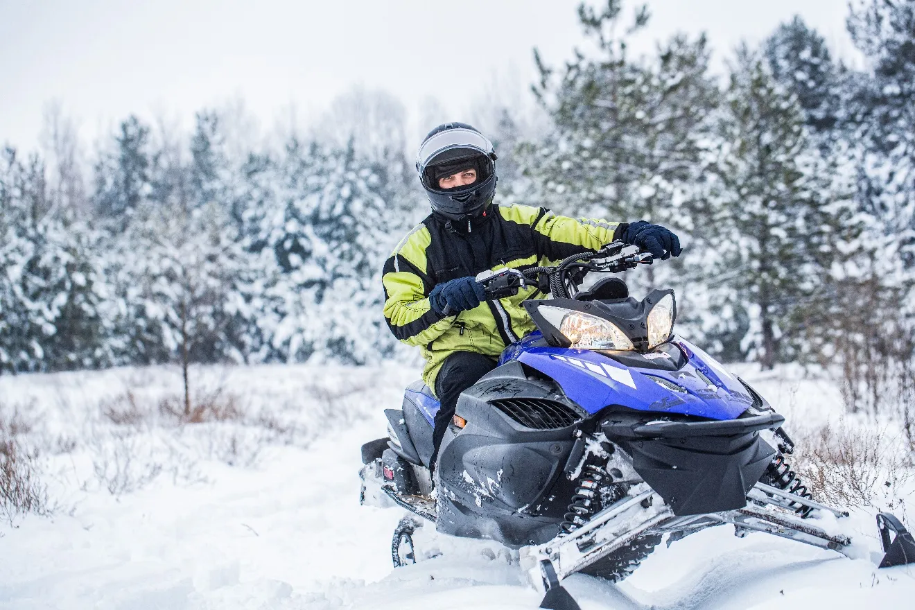 An image containing exterior, snowmobile, snow, tree